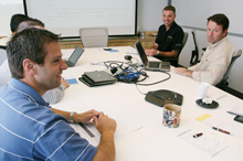 Employees sit at a table during a meeting at Merkle
